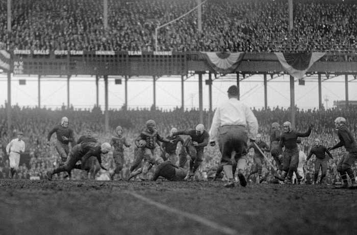 people play football on the field in black and white